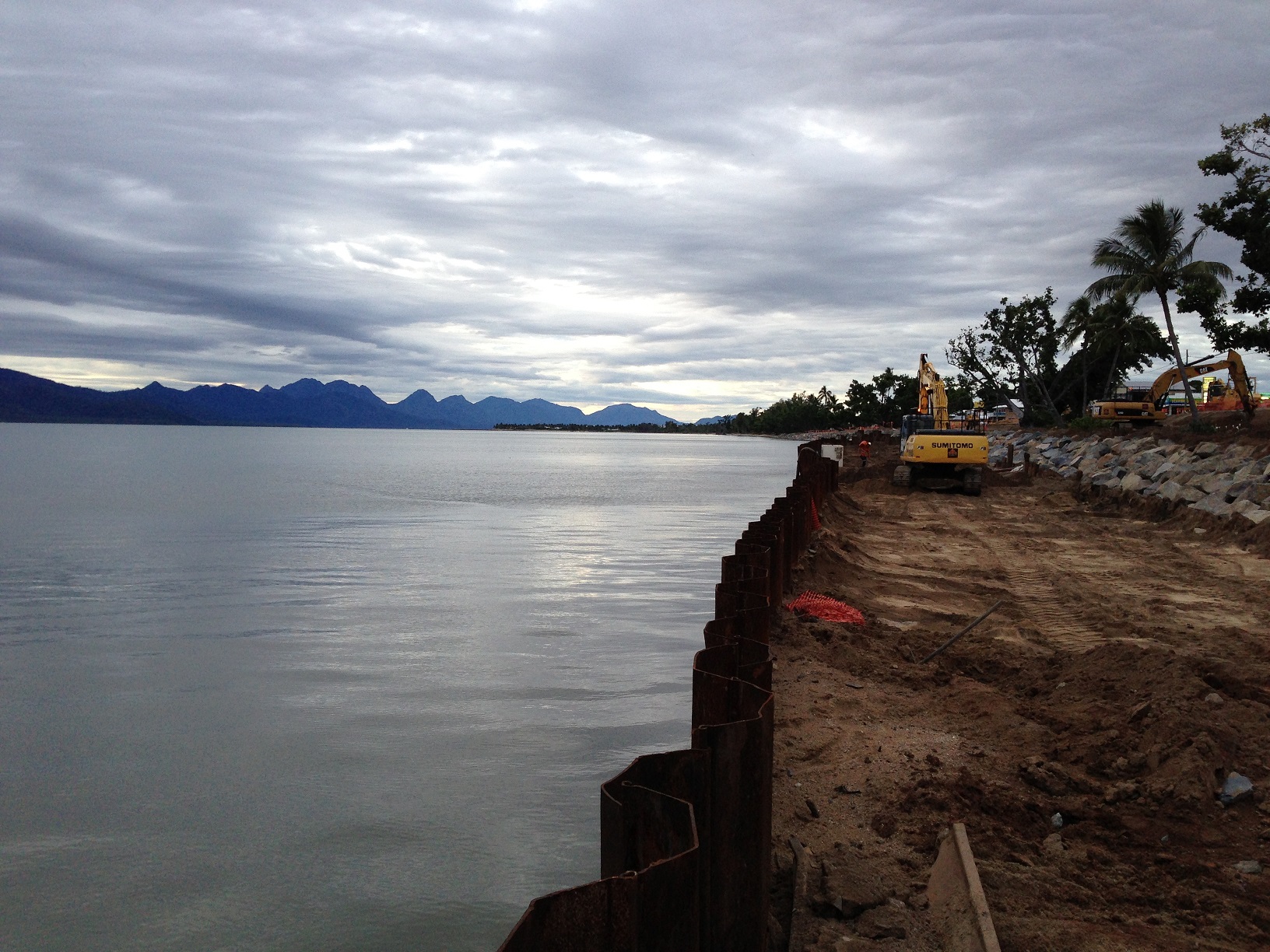 An excavator placing rocks to construct the new rock seawall